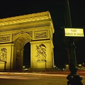 Place Charles de Gaulle street sign and the Arc de Triomphe illuminated at night